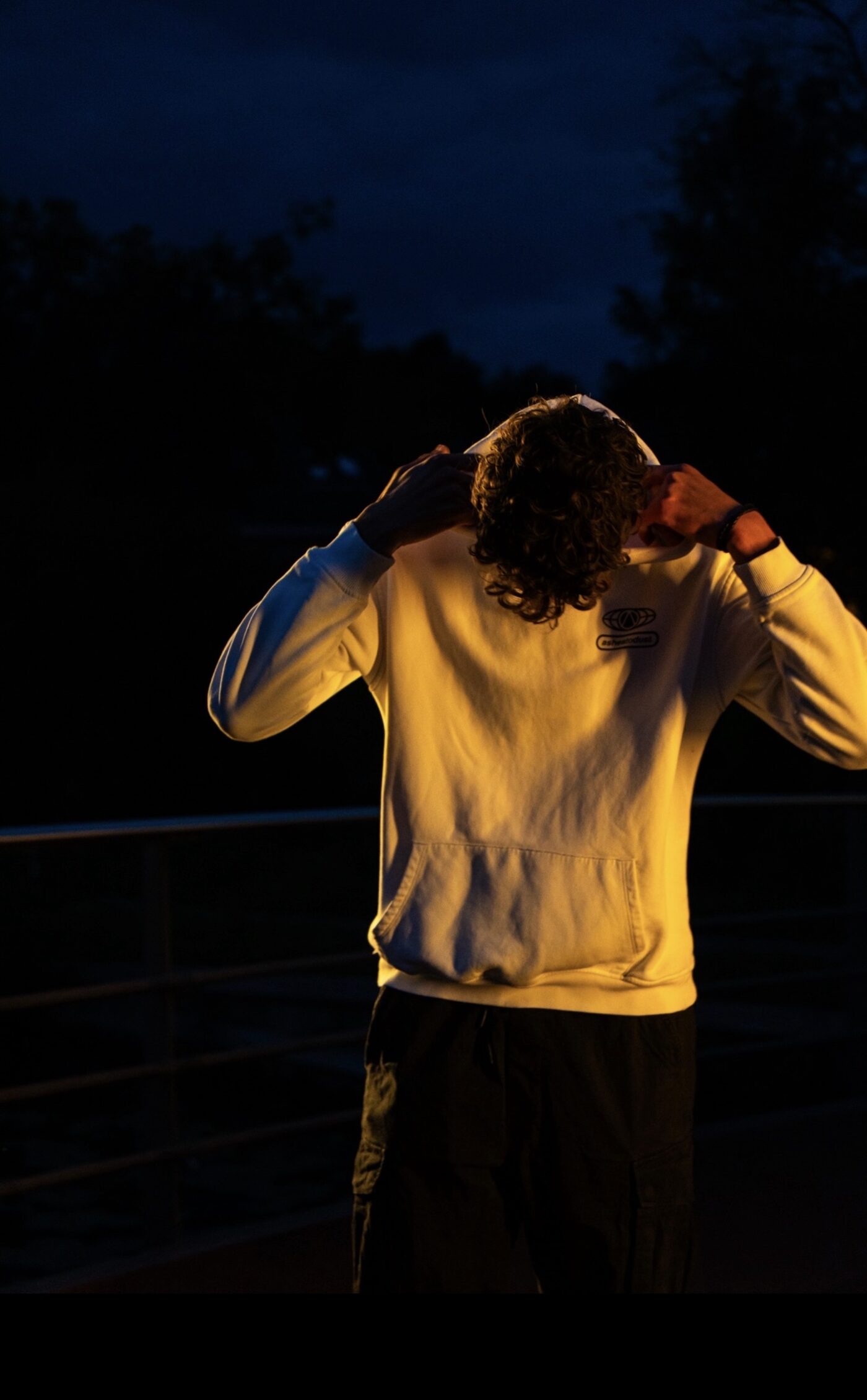 VXNISH pulling up his hood at dusk